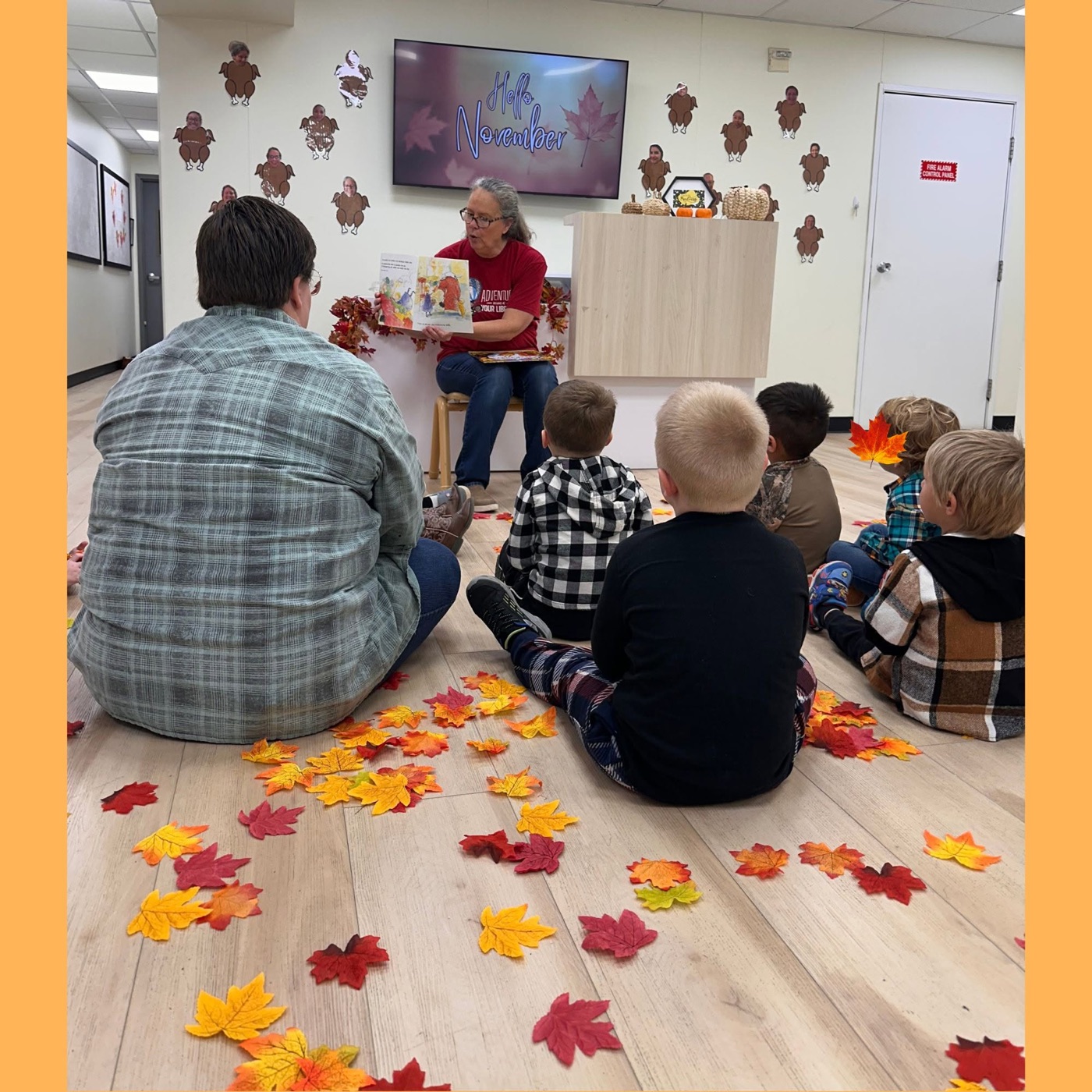 Children gathered on the floor for a cozy story time among autumn leaves